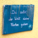 Körpertherapie Psychotherapie Freiburg Ettenheim Heilpraktikerin Praxis (3) Blaues Holzschild mit dem Spruch "Du sollst der Welt deine Farbe geben" in der Körpertherapie Praxis in Ettenheimweiler